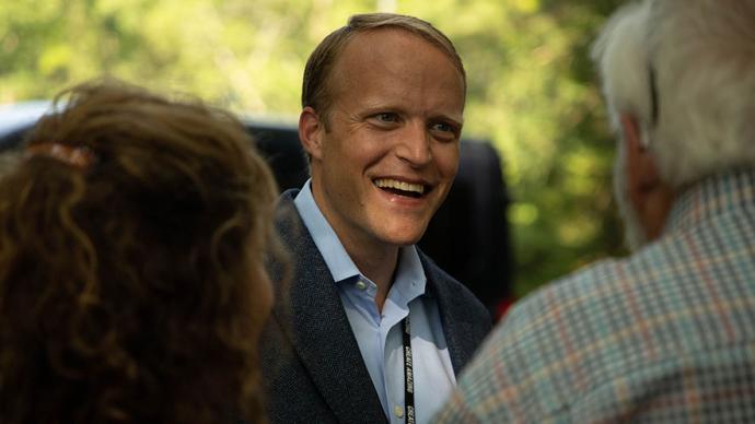 Trey Devey speaks with attendees at an event